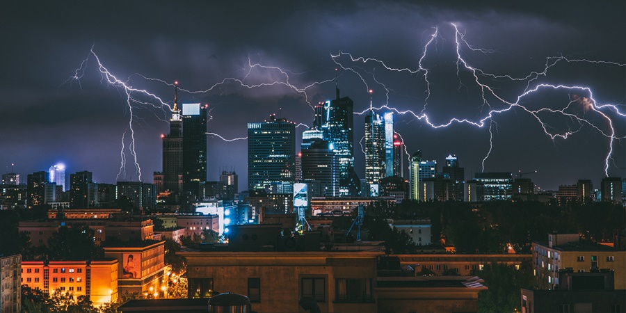night view of a city struck by several lightning