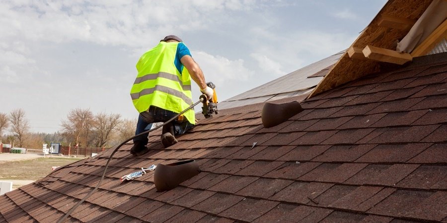 Worker making som roof repairs to a house