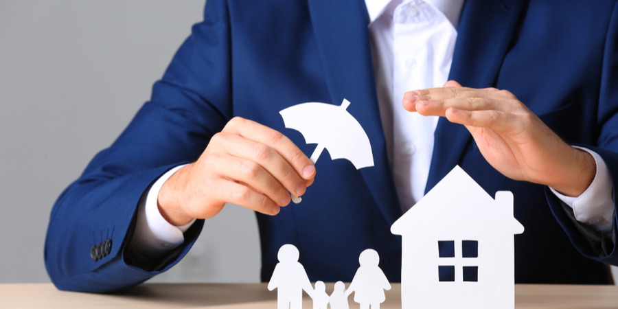 Man holding an umbrella protecting a home and a family