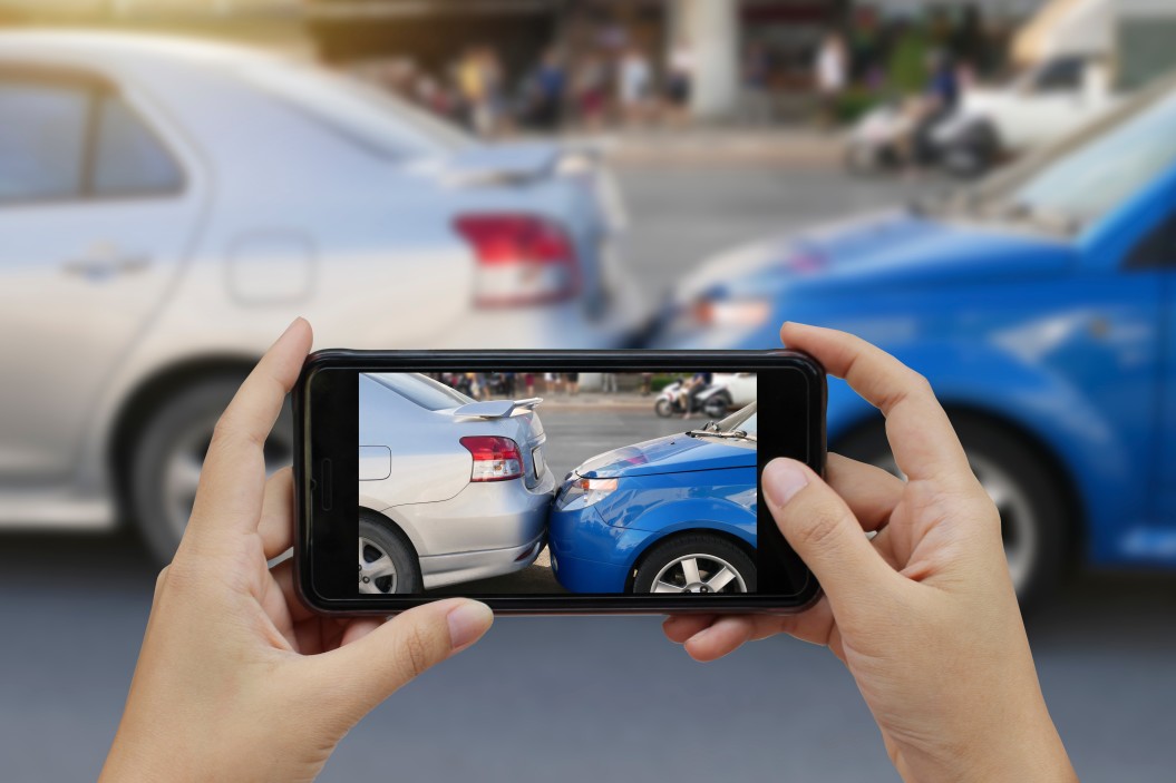 two car accident seen through the screen of a mobile device capturing the incident