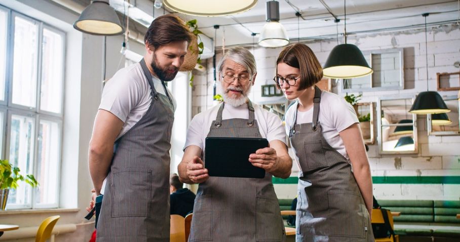 Chef and sous chefs looking at menu in a restaurant