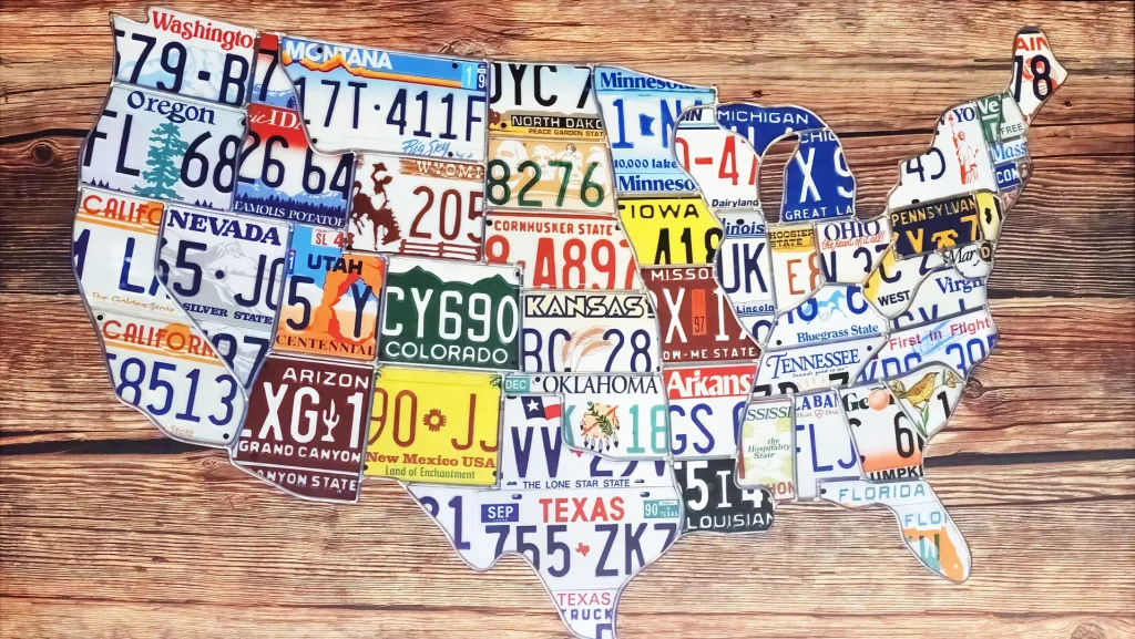 USA map made of vintage state license plates on wooden background.